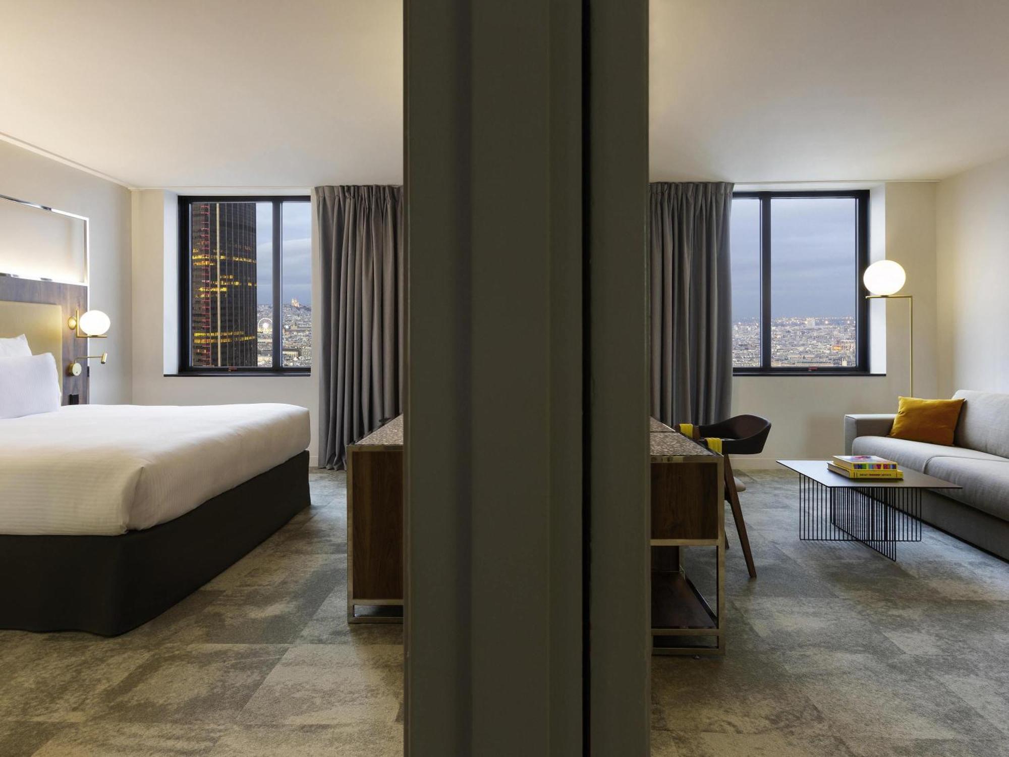 Deluxe Suite mit einem Kingsize-Bett und einem Sofa mit Blick auf die Stadt